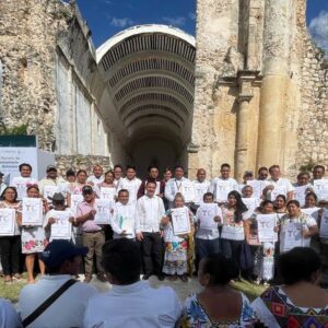Yucatán se posiciona como líder nacional en turismo comunitario con 61 distintivos federales la revista del sureste mx Una Toma De Ángulo Bajo Frente A Las Ruinas De La Iglesia Colonial De Tihosuco, Quintana Roo. Un Gran Grupo De Prestadores De Servicios Turísticos De Yucatán Posa Orgullosamente Sosteniendo Sus Certificados Enmarcados.