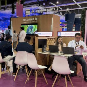 Un Plano De Ángulo Medio Que Captura La Actividad En El Stand De Exhibición De &Amp;Quot;Colombia Co - El País De La Belleza&Amp;Quot; En Una Gran Feria Comercial Como El Tianguis Turístico.