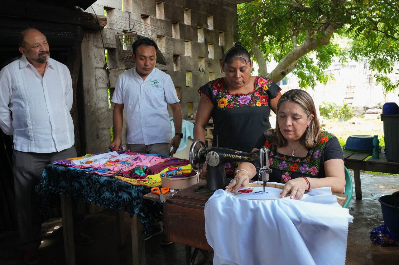 Co’ox mayab: el rugido del turismo comunitario de yucatán resuena en el escenario mundial de brasil la revista del sureste mx Una Mujer Sentada Frente A Una Máquina De Coser Antigua De La Marca Singer, Concentrada En Realizar Un Bordado Floral Sobre Una Tela Blanca Tensada En Un Bastidor Circular.