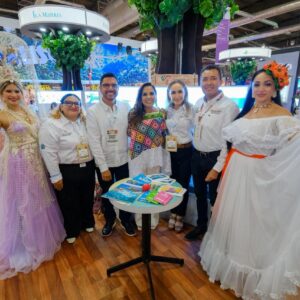 La Gobernadora Mara Lezama Espinosa, Junto A La Secretaria Josefina Rodríguez Y Representantes Del Sector, Posan En El Pabellón Del Caribe Mexicano. Están Acompañados Por Modelos Con Trajes Regionales Y Fantásticos, Rodeados De Elementos Que Promueven Destinos Como Isla Mujeres Y Bacalar.