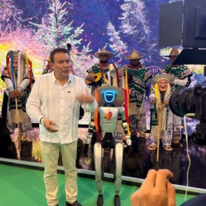 Un Robot Humanoide Con Sombrero Tradicional Y El Logo De Michoacán Posa Junto A Un Presentador Y Artistas Folclóricos En El Tianguis Turístico 2026.