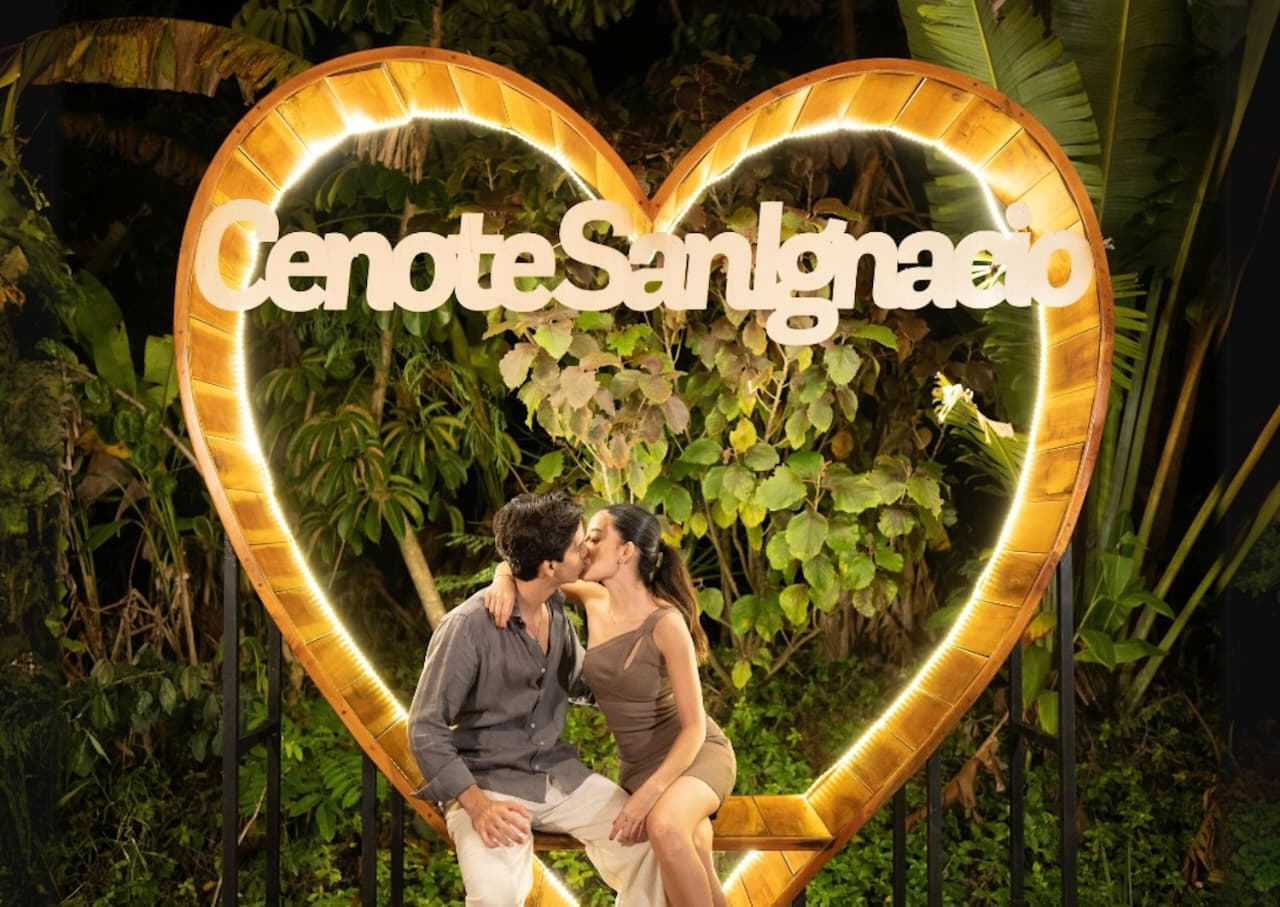 Yucatán hace historia: único estado en recibir doble galardón nacional a la innovación turística 2026 la revista del sureste mx Una Pareja Joven Se Besa Románticamente Sentada Dentro De Una Estructura De Madera En Forma De Corazón Gigante, La Cual Está Iluminada Con Luces Led Blancas En Su Contorno. En El Centro Del Corazón Se Lee El Letrero &Quot;Cenote San Ignacio&Quot; En Letras Blancas.