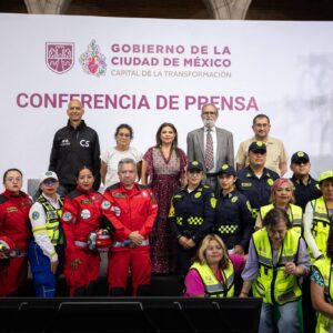 Fotografía De La Jefa De Gobierno De La Ciudad De México, Clara Brugada Molina, Encabezando Una Conferencia De Prensa Sobre El Primer Simulacro Nacional 2026. Se Encuentra Al Centro, Acompañada Por Funcionarios Y Un Grupo Diverso De Elementos De Los Cuerpos De Emergencia, Seguridad Y Protección Civil, Quienes Visten Sus Uniformes Oficiales En Colores Rojo, Azul Y Chalecos De Alta Visibilidad.