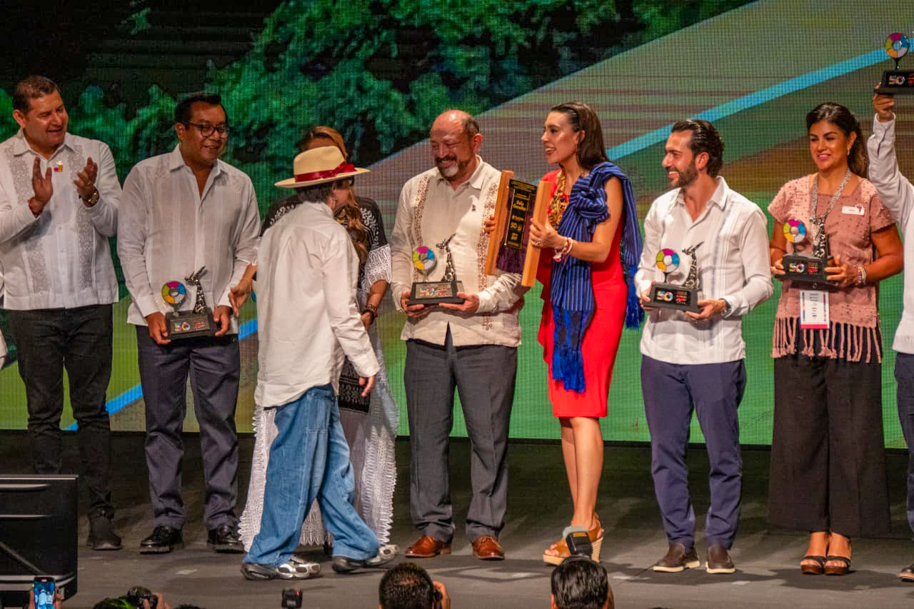 Grupo De Autoridades Y Galardonados En Un Escenario Durante La Gala De Premiación A Lo Mejor Del Turismo Mexicano 2026. Se Observa A La Secretaria De Turismo, Josefina Rodríguez Zamora, Entregando Un Reconocimiento De Madera, Mientras Otros Asistentes Sostienen Estatuillas Con Logotipos Del 50 Aniversario Del Tianguis Turístico.