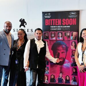 De méxico a cannes: lauand omar sacude el fantastic pavilion 2026 con "bitten soon", una sátira de vampiros y horror político la revista del sureste mx Fotografía En Plano Entero Que Muestra A Seis Personas Posando Alineadas En Un Evento Promocional Frente A Un Fondo Blanco Con Logotipos Comerciales, Entre Los Que Destaca &Amp;Quot;Fantastic Pavilion&Amp;Quot;. En El Centro De La Imagen Hay Un Póster Vertical De Color Negro Y Rosa Con El Título &Amp;Quot;Bitten Soon&Amp;Quot;, El Cual Muestra El Rostro De Un Hombre Con Colmillos De Vampiro Rodeado De Pequeños Retratos De Elenco.
