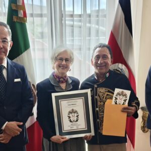 El Chef Yucateco José Luis Alcocer Rodríguez, &Amp;Quot;El Príncipe Maya&Amp;Quot;, Sostiene Un Reconocimiento Enmarcado (#Sellom) Junto A Funcionarios En Costa Rica. Viste Una Filipina Negra Con Bordados Prehispánicos Dorados. Al Fondo Se Observan Las Banderas De México Y Costa Rica.