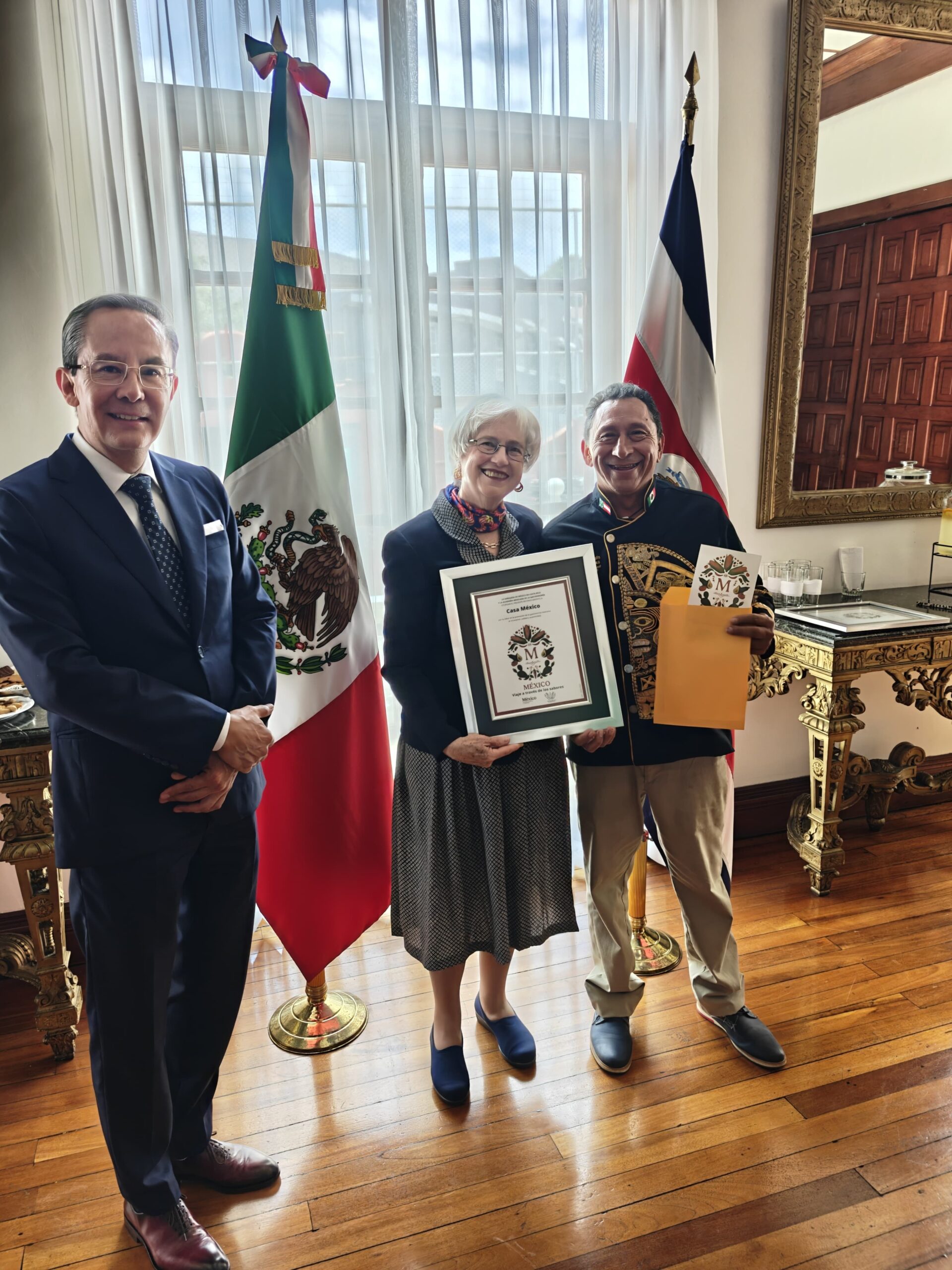 Aquí Tienes Las Propuestas De Texto Alternativo Y Leyenda Para La Imagen Referenciada, Optimizadas Para Accesibilidad Y Redes Sociales:

Texto Alternativo (Alt Text)
Fotografía De Cuerpo Completo En Interiores Que Muestra Al Chef Yucateco José Luis Alcocer Rodríguez, Conocido Como El “Príncipe Maya”, Recibiendo El Distintivo #Sellom En Costa Rica. El Chef Viste Una Filipina Negra Con Intrincados Bordados Dorados De Inspiración Prehispánica Y Sostiene Un Sobre Amarillo.