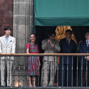 La Presidenta Claudia Sheinbaum Pardo, Vestida Con Un Diseño Tradicional En Colores Rojo Y Azul, Posa En El Balcón Central De Palacio Nacional Junto A Los Siete Integrantes Del Grupo Surcoreano Bts.