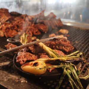 ¡orgullo del norte! National geographic nombra a la gastronomía de sonora entre los 15 mejores destinos culinarios del mundo la revista del sureste mx Una Imagen De Primer Plano Enfocada En Una Sartén De Hierro Fundido Caliente Que Contiene Un Trozo De Carne Asada Chisporroteante, Cebolletas Asadas Carbonizadas Y Una Verdura De Color Amarillo Pálido.