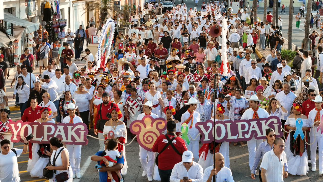 Yolpaki 2026: rocío nahle consolida el mayor encuentro de los pueblos originarios de veracruz la revista del sureste mx Fotografía Aérea En Ángulo Picado Que Muestra El Desfile Masivo Del Festival &Quot;Yolpaki&Quot; Avanzando A Lo Largo De Una Amplia Avenida Costera En El Puerto De Veracruz. Al Frente Del Contingente, Varias Personas Vestidas De Blanco Sostienen Letras Y Letreros Grandes En Color Morado Y Rosa Que Forman La Palabra &Quot;Yolpaki&Quot;.