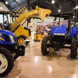 Yucatán será sede de la expo pro agro innovación 2026 la revista del sureste mx Fotografía Del Interior Del Centro De Convenciones Y Exposiciones Yucatán Siglo Xxi Durante La Expo Pro Agro Innovación 2026. En Primer Plano, Se Exhiben Tractores Agrícolas Modernos De La Marca New Holland En Colores Azul Brillante.