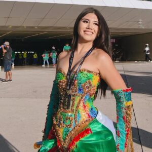 ¡de calkiní para el mundo! Diseño campechano brilla en el estadio akron durante el mundial 2026 la revista del sureste mx La Influencer Friday Frida Sonríe Posando Frente Al Acceso Principal Del Estadio Guadalajara (Estadio Akron). Viste Un Elaborado Traje Artesanal Strapless Multicolor, Con Pedrería Brillante En Tonos Verdes, Dorados Y Rojos, Manguillas Decoradas Con Flecos Dorados A Juego, Y Una Falda Satinada Con Los Colores De La Bandera Mexicana Verde Y Rojo.