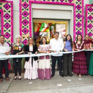 Con toda su cultura, gastronomía e historia, inauguran la "casa hecho en oaxaca" en la ciudad de méxico para promover la riqueza de sus ocho regiones la revista del sureste mx Una Fotografía De Ángulo Medio A Nivel De Los Ojos Captura A Un Grupo De Personas De Pie En Una Línea En Una Acera De Hormigón Frente A La Entrada De Una Tienda. Los Miembros Del Grupo, Una Mezcla De Hombres Y Mujeres, Sonríen Mientras Cortan Una Larga Cinta Azul Claro. Varios Miembros Del Grupo Llevan Ropa Tradicional Mexicana Oaxaqueña, Como Blusas Bordadas Con Flores Y Faldas Completas De Color Rojo, Burdeos Y Verde, Mientras Que Otros Llevan Trajes Empresariales Modernos.
