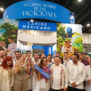 Conoce las 8 experiencias de turismo comunitario con las que maya ka’an y quintana roo deslumbran en k’íiwik 2026 la revista del sureste mx Un Grupo Numeroso De Funcionarios Públicos, Delegados Y Personas Con Vestimentas Tradicionales Posan Sonrientes Para Una Fotografía Grupal Frente Al Pabellón Del Caribe Mexicano. Al Centro, La Gobernadora Mara Lezama Viste Un Huipil Blanco Bordado Con Coloridos Patrones Geométricos Y Sostiene Un Listón Azul Con Letras Blancas Que Dice &Amp;Quot;Caribe Mexicano&Amp;Quot;. A Su Lado Izquierdo Se Encuentra El Gobernador Joaquín Díaz Mena