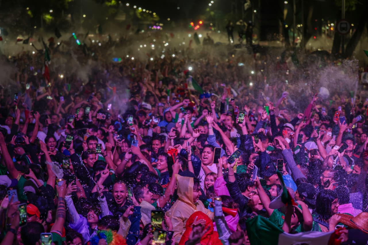 Fiesta histórica en la cdmx: más de 730 mil personas celebran el triunfo de méxico con saldo blanco la revista del sureste mx Una Toma Nocturna En Plano Medio Que Muestra A Una Multitud Densa Y Eufórica De Aficionados Festejando En Las Calles De La Ciudad De México. Las Personas, Muchas De Ellas Vistiendo Camisetas Verdes De La Selección De Fútbol, Llenan El Espacio Por Completo; Levantan Sus Teléfonos Celulares Con Las Luces Encendidas, Agitan Los Brazos Y Lanzan Espuma Blanca Al Aire En Señal De Celebración. Entre La Gente Se Aprecian Banderas De México Y Rostros Llenos De Alegría Y Emoción, Bajo La Iluminación Nocturna De La Avenida.