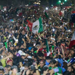 Fiesta histórica en la cdmx: más de 730 mil personas celebran el triunfo de méxico con saldo blanco la revista del sureste mx Una Toma Aérea Nocturna Que Captura Una Densa Multitud De Miles De Aficionados Al Fútbol Celebrando En La Avenida Paseo De La Reforma De La Ciudad De México. La Escena Es Un Mar De Color Y Emoción, Con Innumerables Personas Ondeando Banderas Mexicanas Verdes, Blancas Y Rojas. Muchas Personas En Primer Plano Están Levantando Sus Teléfonos Celulares Iluminados, Creando Un Efecto Brillante En Toda La Multitud. Las Personas Tienen Expresiones De Alegría Y Están Coreando. La Avenida Está Completamente Llena Hasta Donde Alcanza La Vista, Con Semáforos Verdes Y Luces De La Ciudad Borrosas Al Fondo, Subrayando La Escala Del Evento Masivo. La Imagen Captura La Euforia Colectiva Y La Unidad De Los Aficionados Mexicanos.