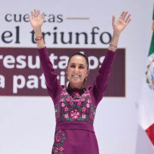 Sheinbaum celebra dos años del triunfo electoral: balanza económica estable y defensa de la soberanía nacional la revista del sureste mx La Presidenta De México, Claudia Sheinbaum Pardo, Sonríe Y Saluda Con Ambos Brazos Levantados Desde El Presídium Durante Su Informe De Gobierno. Viste Un Vestido Color Magenta Con Bordados Florales Tradicionales En El Pecho. Al Fondo, Se Aprecia Parte De Una Lona Oficial Con Letras Guindas Y La Bandera De México A Un Costado.