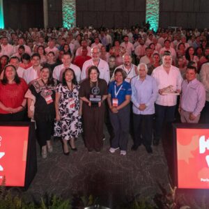 Yucatán consolida con éxito la feria k’íiwik 2026 y sella el futuro de la integración turística en el mundo maya la revista del sureste mx Una Fotografía Grupal A Nivel De Piso En Una Conferencia En Interiores, Con Una Gran Multitud De Asistentes De Pie En El Fondo, Muchos Vestidos De Blanco. En El Centro Del Primer Plano, Un Grupo De Dignatarios Está De Pie, Incluidos Varios Oradores Y Funcionarios, Algunos Sosteniendo Premios O Estafetas. Dos Pantallas Led Brillantes En El Borde Delantero De La Audiencia Muestran El Logotipo De 'K’íiwik 2026' Con El Subtítulo 'Feria Turística Del Mundo Maya'. El Fondo De La Multitud Está Sutilmente Iluminado Con Luces Verdes Y Turquesas.