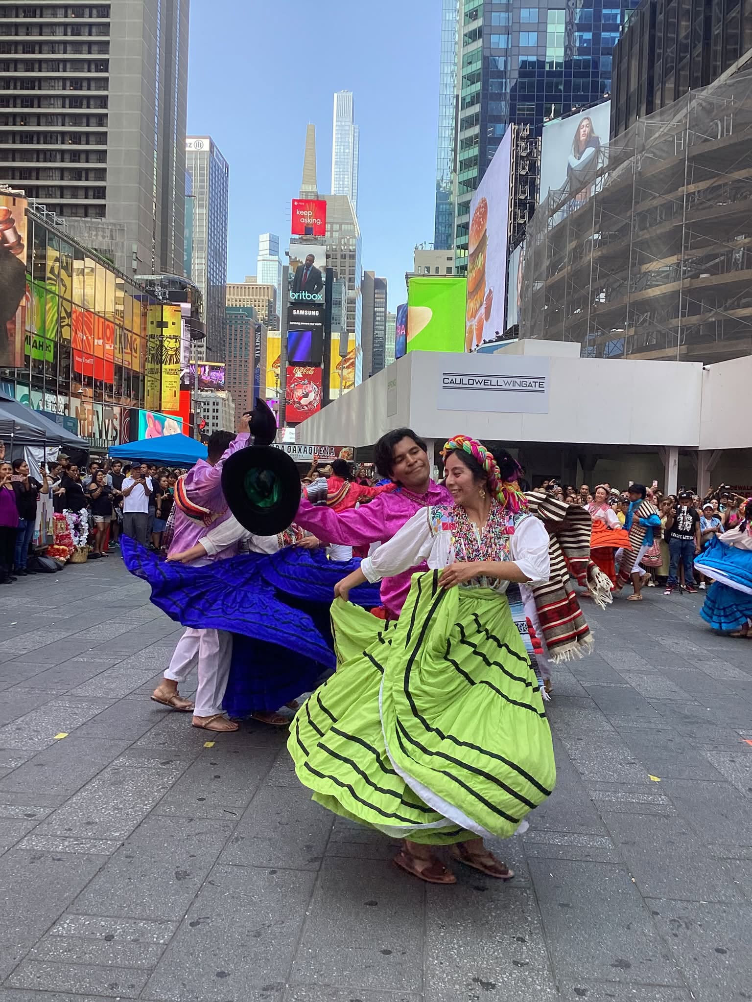 Pareja De Bailarines Oaxaqueños Ejecuta Una Danza Tradicional Con Falda Verde Y Camisa Rosa En La Plaza Peatonal De Times Square.