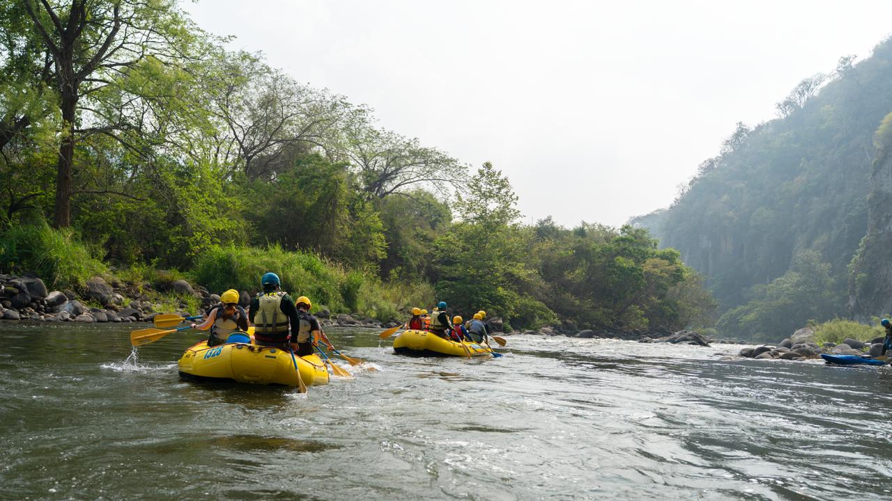 Región cultura y aventura: el corazón histórico de veracruz la revista del sureste mx Grupo De Personas Realizando Rafting En Balsas Amarillas Sobre Un Río Flanqueado Por Árboles Y Montañas.