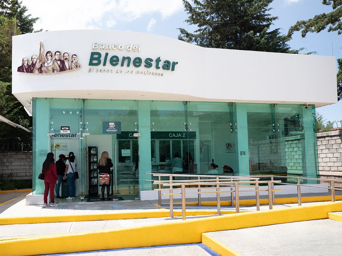 Fachada Moderna De Una Sucursal Con Personas En Ventanilla Y Cajero, Representativa De La Calificación Crediticia Del Banco Del Bienestar Ratificada Por Fitch Ratings.
