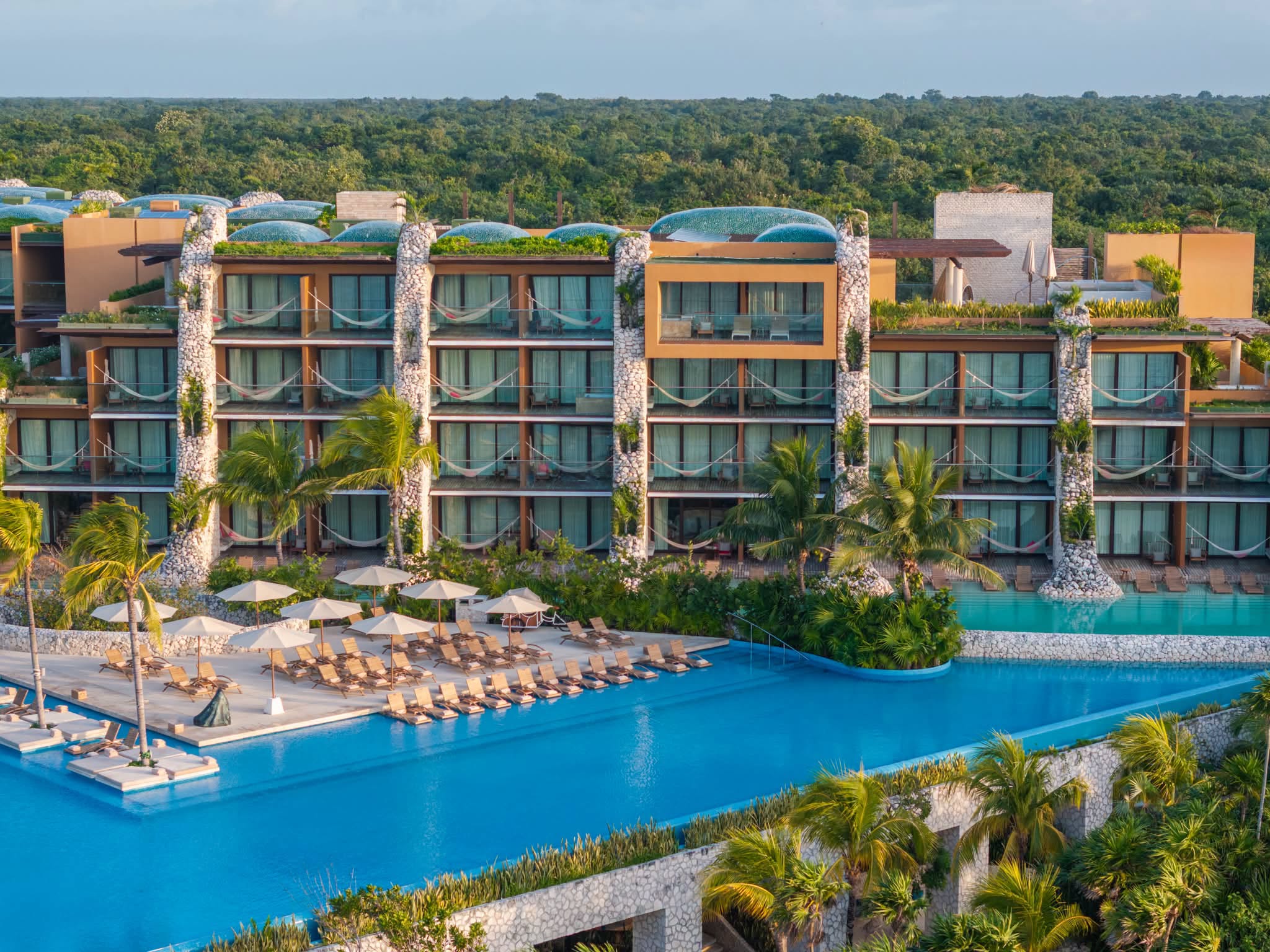 La liste reconoce a hotel xcaret arte con el style & design hotel award 2026 la revista del sureste mx Vista Frontal Del Hotel Xcaret Arte Mostrando Su Arquitectura Eco-Integradora, Suites Con Balcones Y Hamacas, Y Su Piscina Con Vista Al Entorno Natural De La Riviera Maya.
