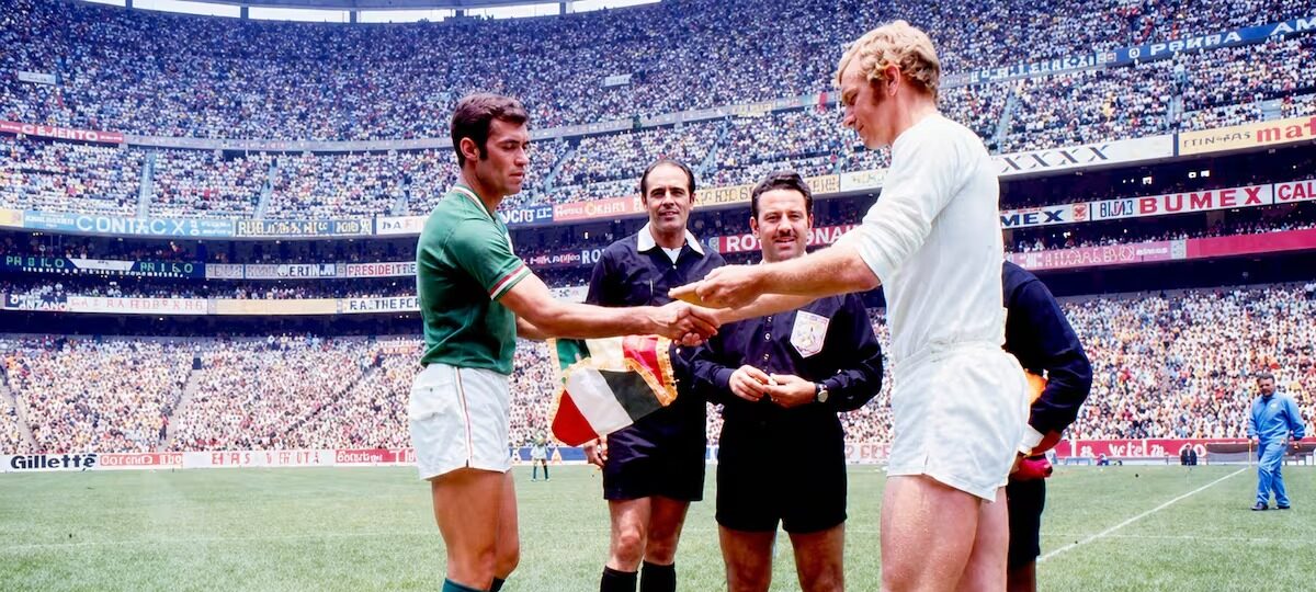 : Fotografía Histórica En El Estadio Azteca Donde Los Capitanes De Las Selecciones De México E Inglaterra Intercambian Banderines Previo A Un Encuentro, Acompañados Por El Árbitro Central.