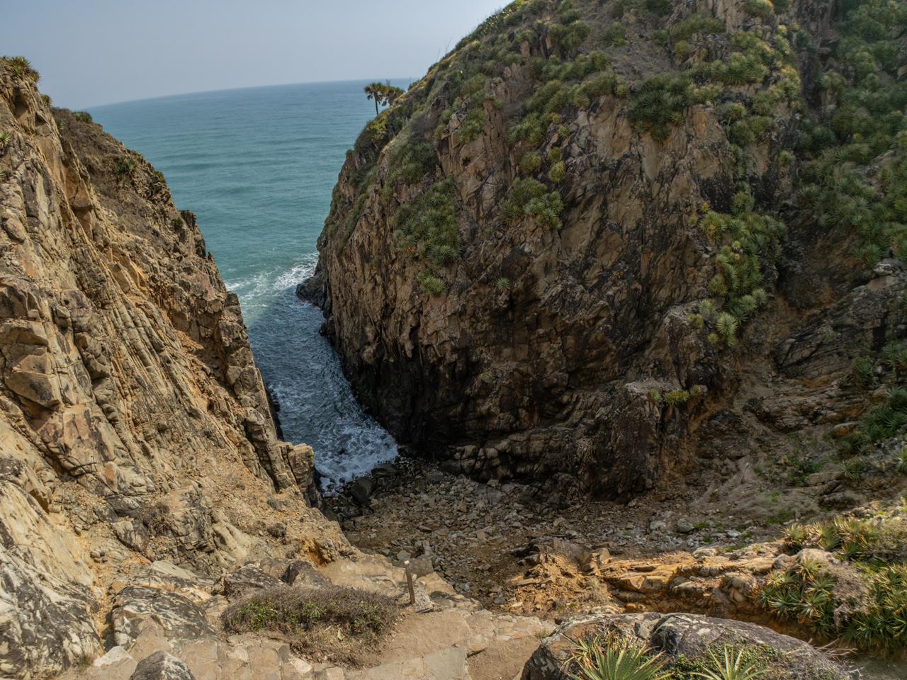 Región cultura y aventura: el corazón histórico de veracruz la revista del sureste mx Acantilados Rocosos Que Forman Una Estrecha Entrada Hacia El Mar En La Costa De Veracruz, Con Vegetación Sobre Las Rocas Y Una Pequeña Playa De Piedras.