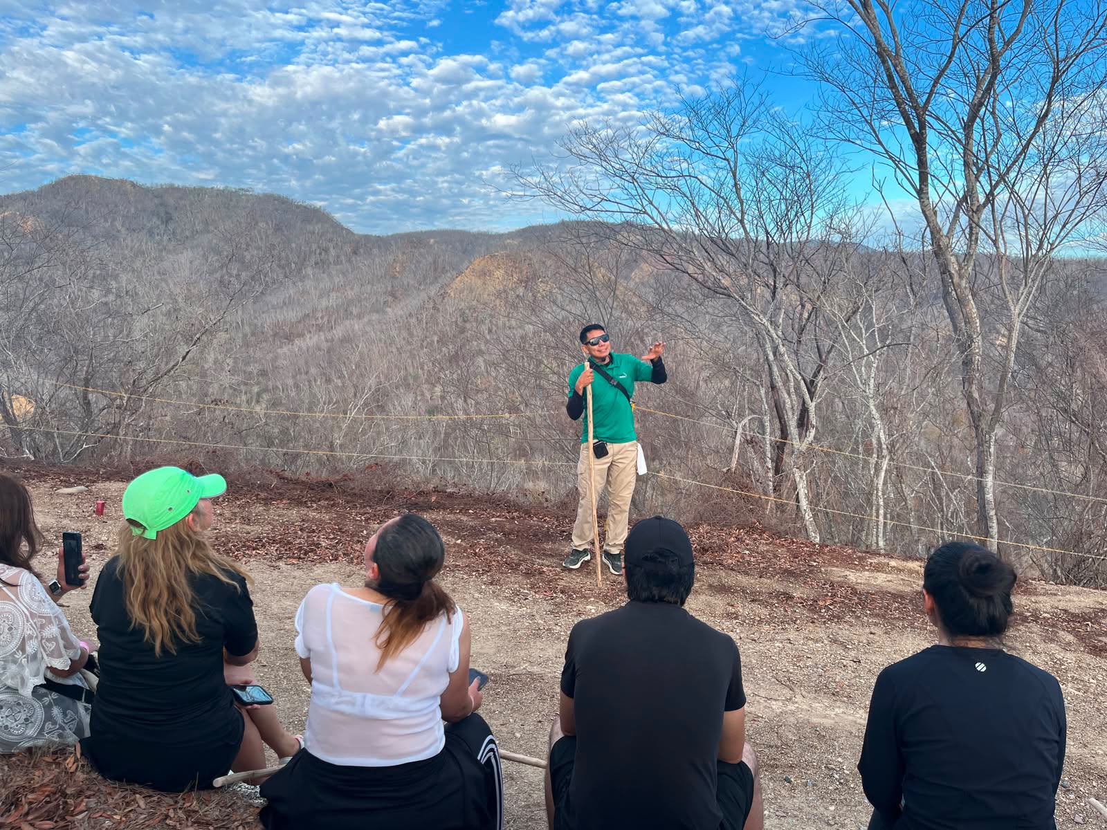 Sectur pide contratar guías de turistas certificados en méxico la revista del sureste mx Guía De Turistas Acreditado Explica Un Recorrido Al Aire Libre Frente A Un Grupo De Visitantes En Un Mirador Montañoso Durante Una Actividad De Senderismo En México, Rodeado De Paisaje Natural Y Cielo Parcialmente Nublado.