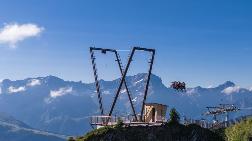 Columpio Gigante En Los Alpes Suizos Suspendido Sobre Un Impresionante Paisaje Montañoso, Donde Varios Visitantes Disfrutan De Una Experiencia Extrema Con Vistas Panorámicas Al Grand Chamossaire.
