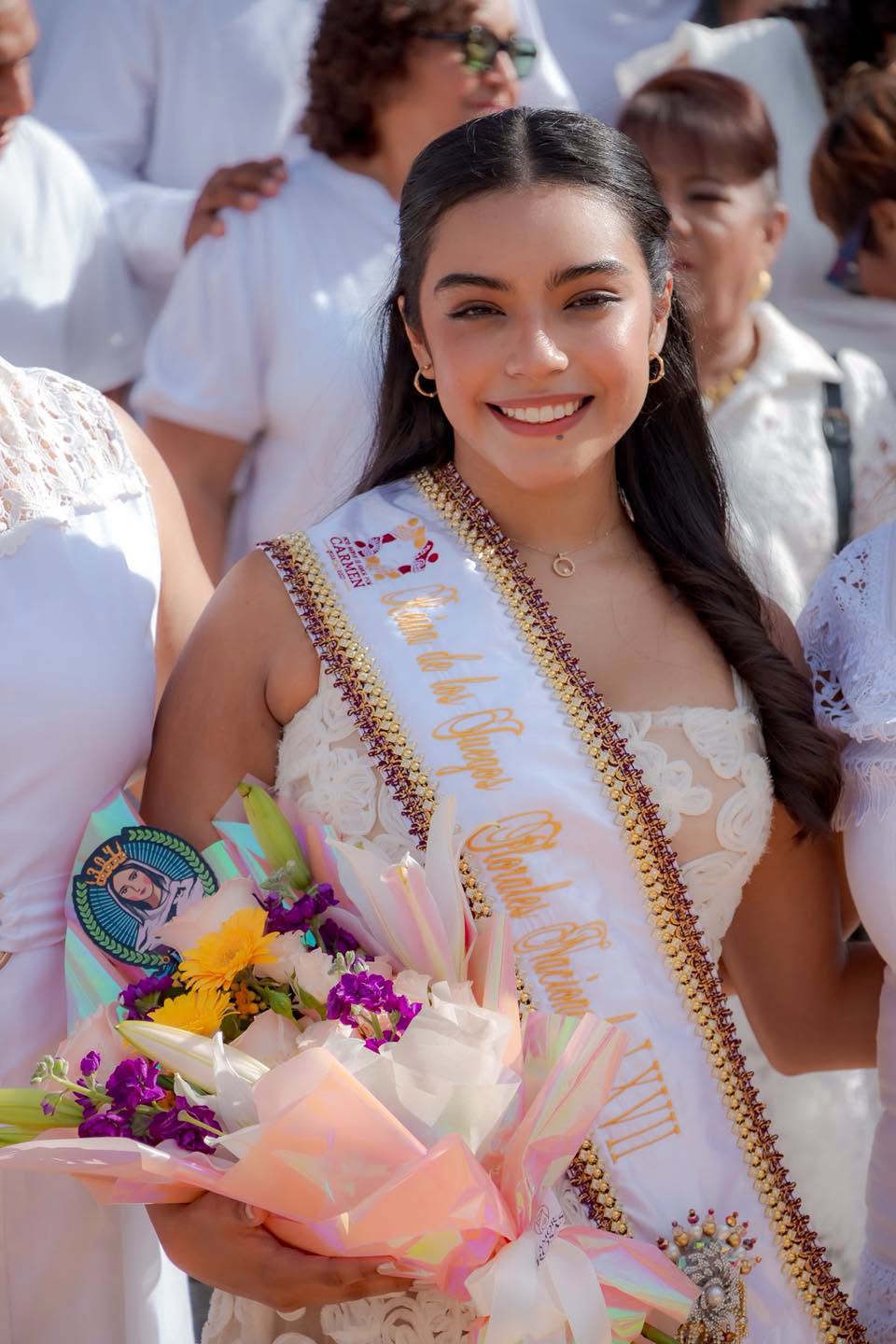 Celebración del 170. º aniversario de la titulación de ciudad del carmen como ciudad: valentina álvarez como embajadora de orgullo y tradición la revista del sureste mx Valentina Desiree Álvarez Marín Sonriendo, Luciendo Su Banda Oficial Como Soberana De Los Lxvii Juegos Florales Nacionales Y Feria Carmen 2026, Sosteniendo Un Ramo De Flores.