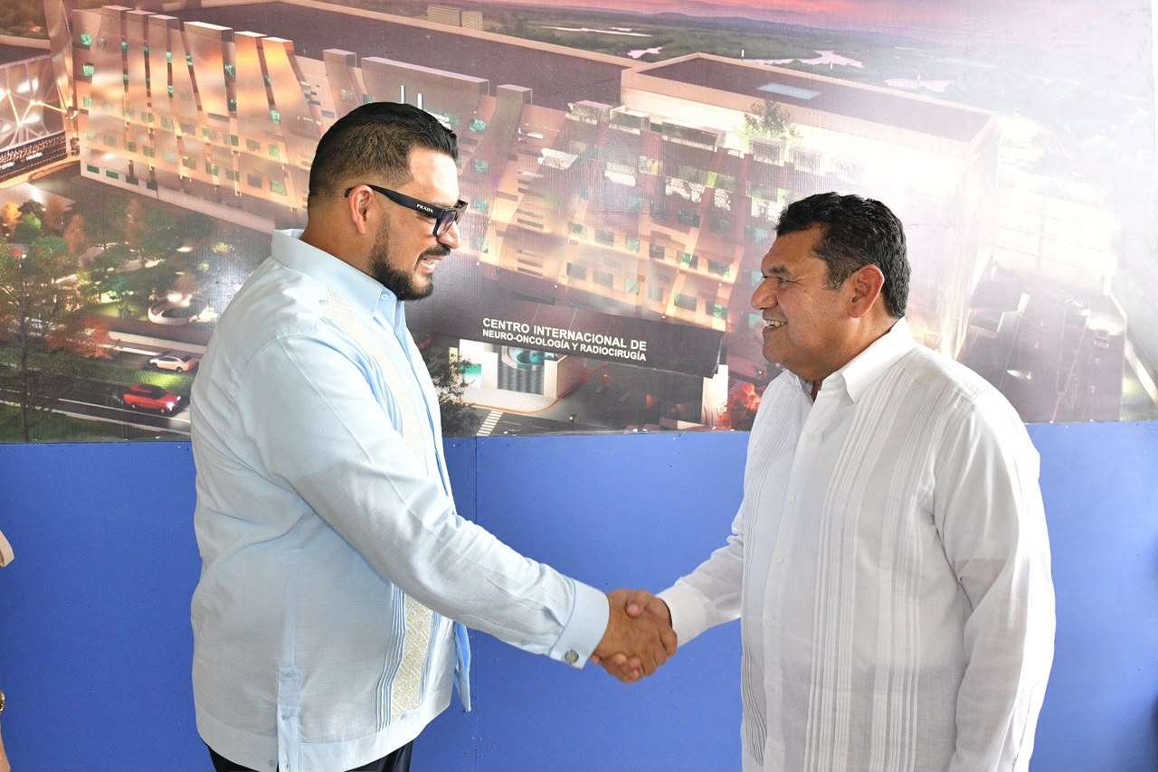 El Ceo De Hospitales Zumaya, Alejandro Yussef Nieves (Izquierda), Y El Gobernador De Tabasco, Javier May Rodríguez (Derecha), Vestidos Con Camisas Guayaberas, Se Estrechan La Mano Y Sonríen. El Ceo Viste Una Guayabera Azul Claro Con Gafas Y Barba, Mientras Que El Gobernador Viste Una Guayabera Blanca. Ambos Están De Pie Frente A Un Renderizado Arquitectónico Del Proyecto Hospitalario Que Incluye El Texto Visible: &Quot;Centro Internacional De Neuro-Oncología Y Radiocirugía Zumaya&Quot;.