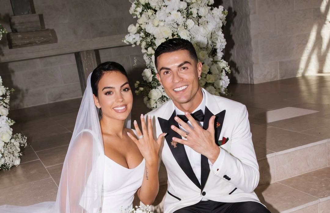 Hermetismo, fechas filtradas y lujo absoluto: todo lo que se sabe sobre la esperada boda de cristiano ronaldo y georgina rodríguez la revista del sureste mx Imagen Creada Con Inteligencia Artificial De Cristiano Ronaldo Y Georgina Rodríguez Vestida De Novia Mostrando Sus Anillos De Matrimonio.