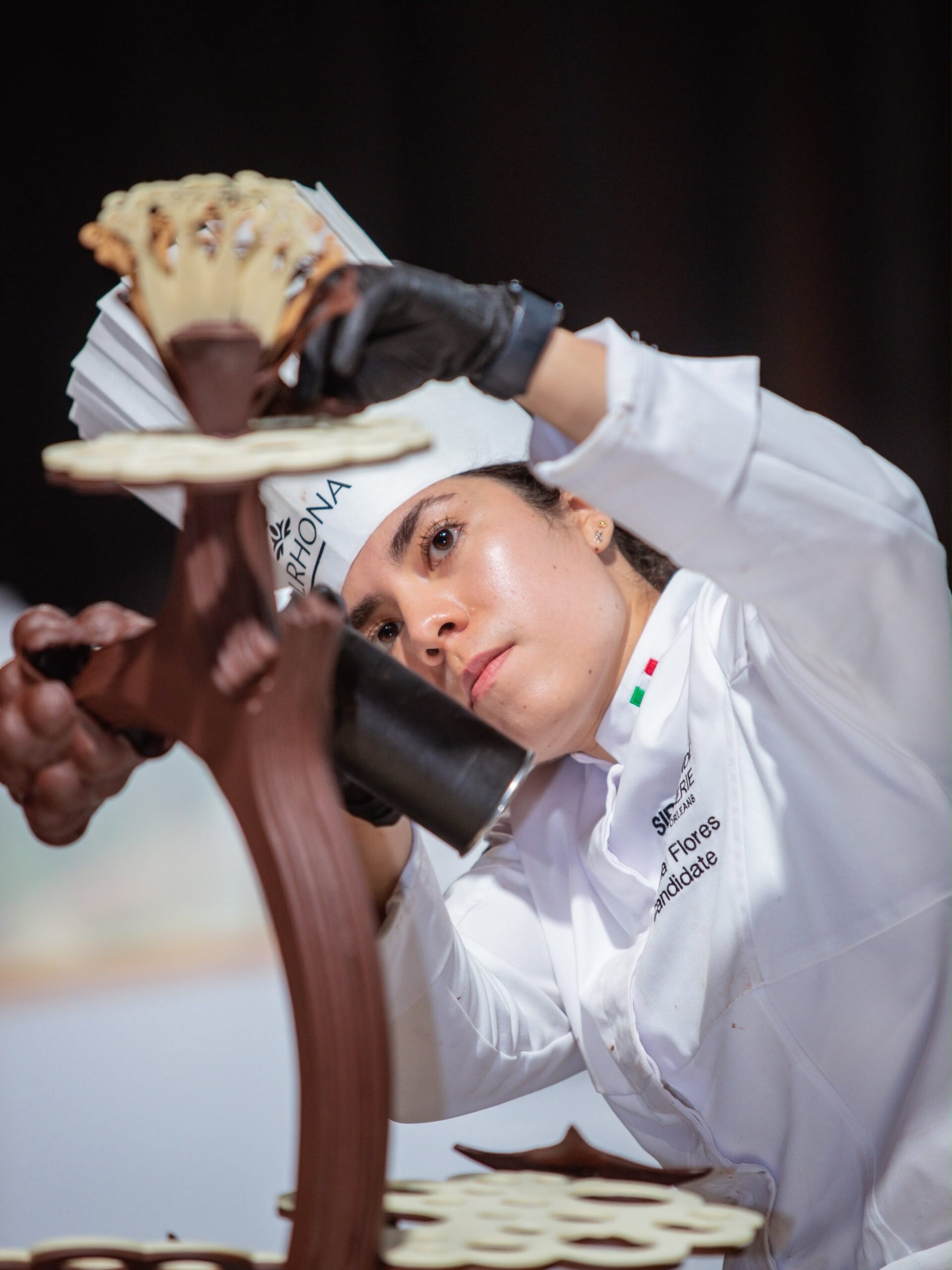 La Repostera Mexicana Roxana Flores Trabaja Con Precisión Concentrada En El Ensamblaje De Una Compleja Escultura De Chocolate Durante Una Competencia De Pastelería.