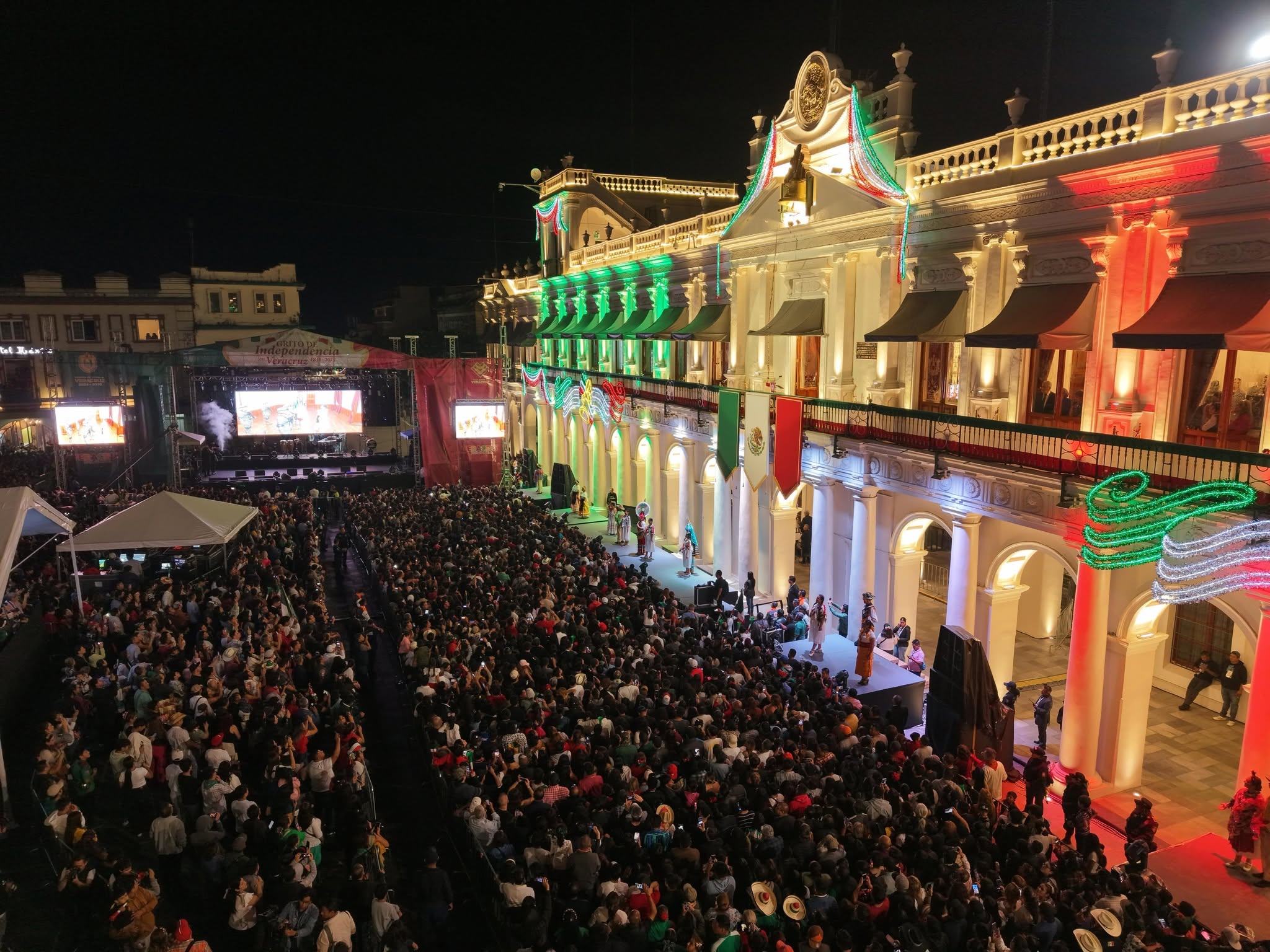 Fotografía Panorámica Nocturna De Una Plaza Pública Abarrotada Frente A Un Edificio Gubernamental Iluminado Con Motivos Patrios Durante Las Fiestas Del Grito De Independencia.