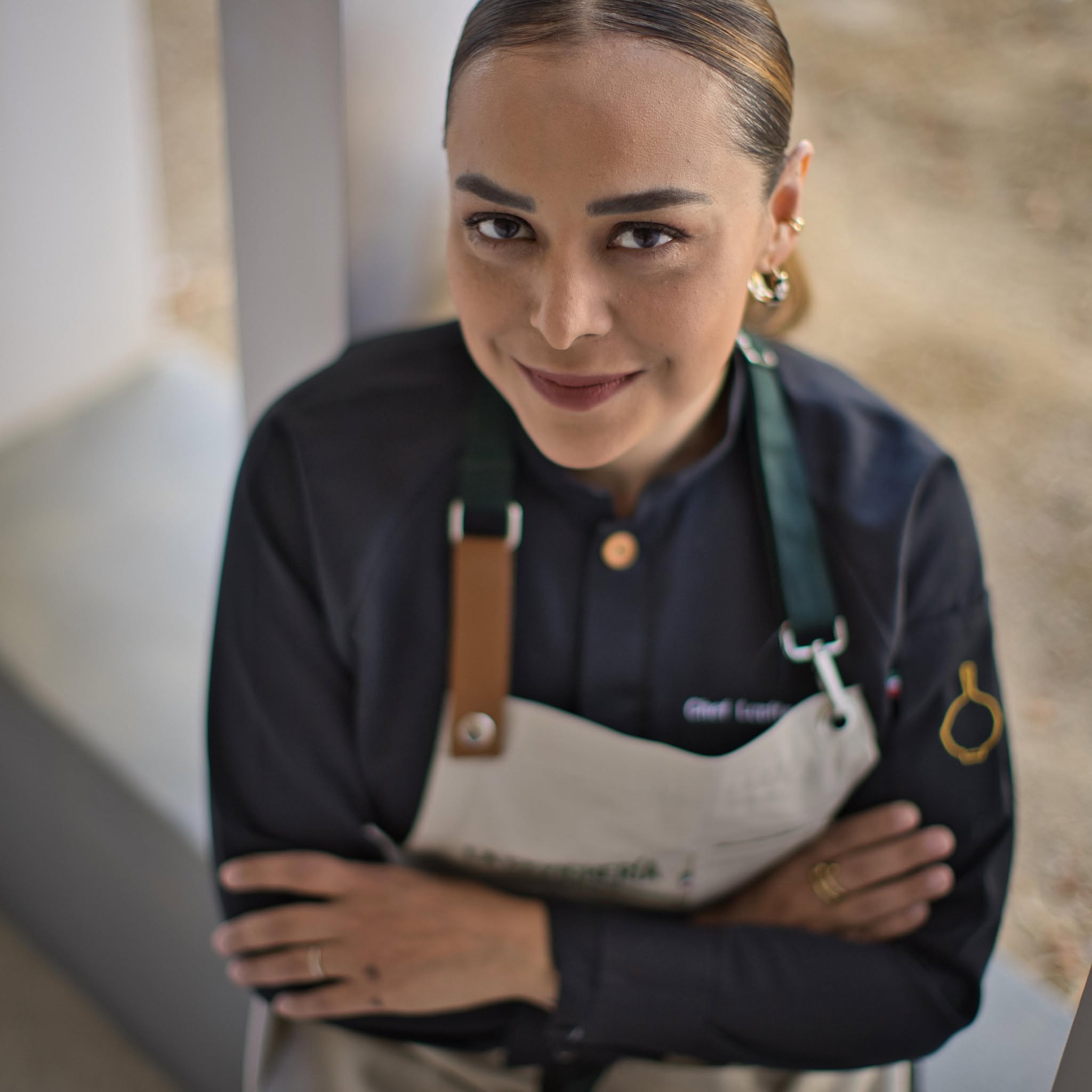 Retrato En Plano Cenital De La Chef Lupita Vidal Con Filipina Oscura Y Delantal Claro.