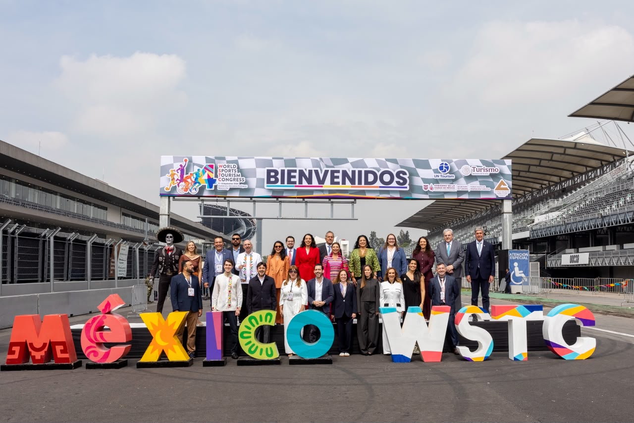 Fotografía Grupal De Autoridades Y Organizadores Frente A Letras Monumentales Con La Leyenda &Quot;México Wstc&Quot; Y Una Lona De Bienvenida Del 4° Congreso Mundial De Turismo Deportivo.