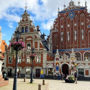 Ellas mandan y ellos se alquilan: el sorprendente fenómeno del país europeo con más mujeres donde se contratan "maridos por hora" la revista del sureste mx Fachada Histórica De La Casa De Los Cabezas Negras En El Casco Antiguo De Riga, Letonia, Con Una Estatua De Un Caballero En Primer Plano, Reflejando El Entorno Urbano De Las Ciudades Donde Operan Los Servicios De &Amp;Quot;Maridos Por Hora&Amp;Quot;.