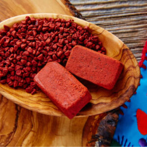 Fiestas patrias y tradición culinaria: los 'recados' de yucatán como el corazón aromático de la gastronomía mexicana la revista del sureste mx Semillas Y Bloques De Recado Rojo De Achiote En Un Recipiente De Madera, Ingrediente Clave De La Gastronomía De Yucatán.