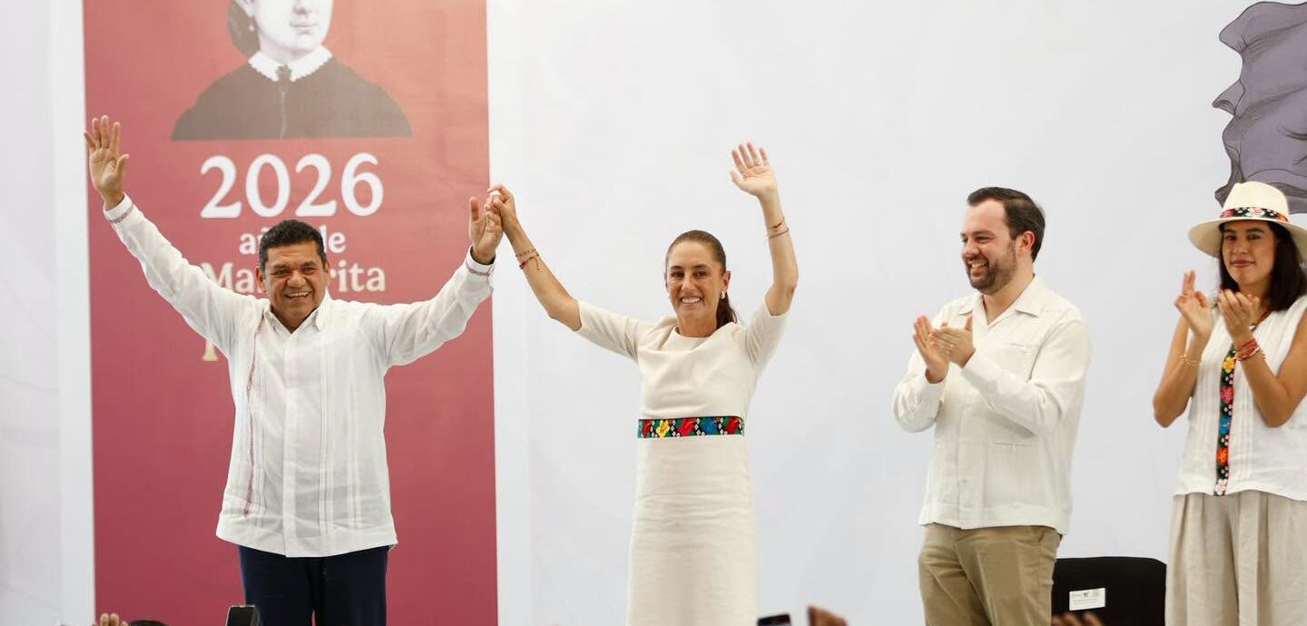 La Presidenta Claudia Sheinbaum Pardo Y El Gobernador De Tabasco, Javier May Rodríguez, Sostienen Las Manos En Alto Sonrientes Ante El Público, Acompañados Por Otras Personas En Un Templete Frente A Asistentes Que Los Saludan Con Teléfonos Celulares Y Manos En Alto.