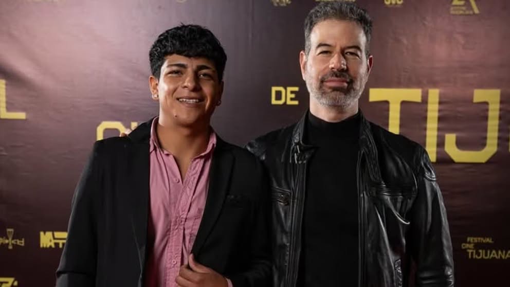 El Director David Pablos Junto Al Actor Osvaldo Sánchez Posando En Una Alfombra Roja Frente Al Mural De Un Festival De Cine.