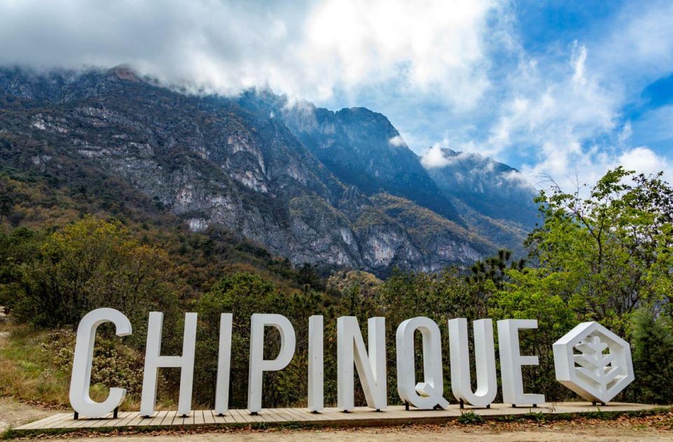 Letras Monumentales Con La Palabra Chipinque Sobre Una Estructura De Madera, Con La Imponente Sierra Madre Y Un Cielo Nublado Al Fondo.