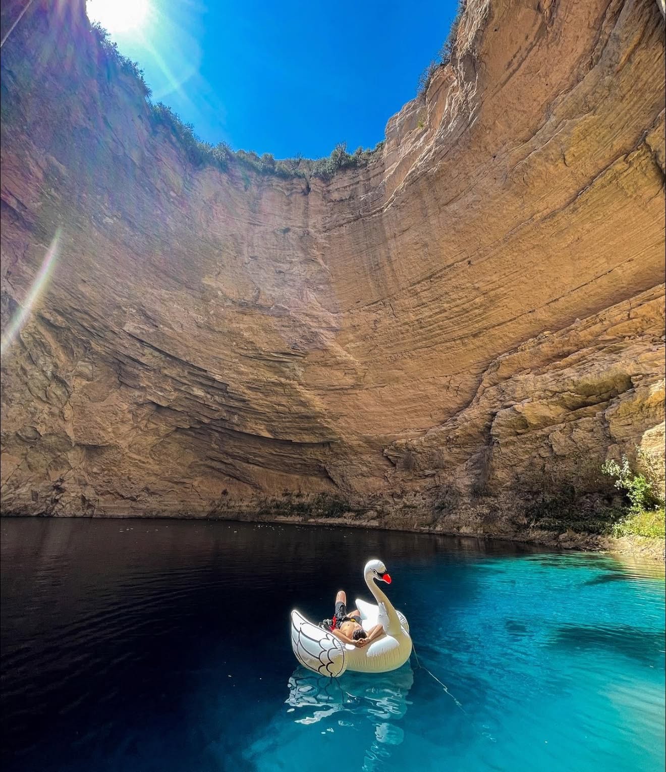 Turista Flotando En Un Inflable Con Forma De Cisne Sobre Las Aguas Turquesas Del Pozo Del Gavilán En Galeana, Nuevo León, Rodeado Por Monumentales Paredes De Roca Caliza.