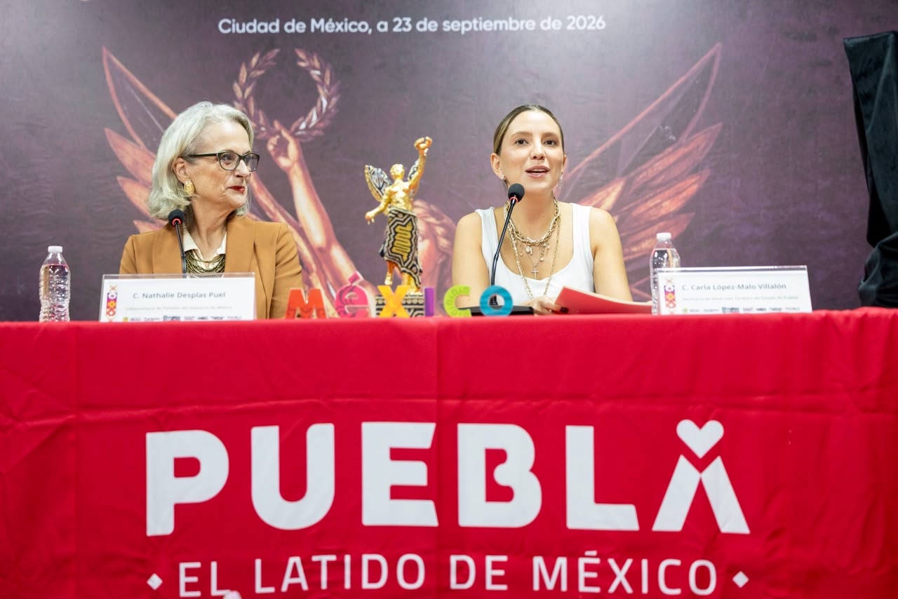Puebla se viste de gala: será la histórica sede de la 11. ª edición de los galardones ángel del turismo 2026 la revista del sureste mx Dos Mujeres En Una Conferencia De Prensa Detrás De Una Mesa Con Mantel Rojo Que Muestra La Leyenda &Quot;Puebla El Latido De México&Quot;, Anunciando Que El Estado Será La Histórica Sede De La 11.ª Edición De Los Galardones Ángel Del Turismo 2026.