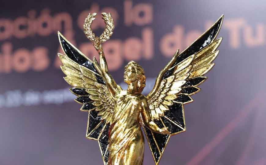 Estatuilla Dorada De Los Galardones Ángel Del Turismo Con Alas Extendidas Y Una Corona De Laureles, Destacando Que Puebla Será La Histórica Sede De Su 11.ª Edición En 2026.