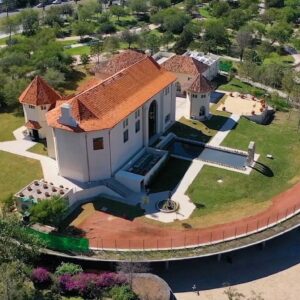 Vista Aérea De La Milarca, Un Edificio De Estilo Colonial Con Techo De Tejas Naranjas Y Torres Cónicas, Situado En Un Parque Arbolado En San Pedro Garza García.